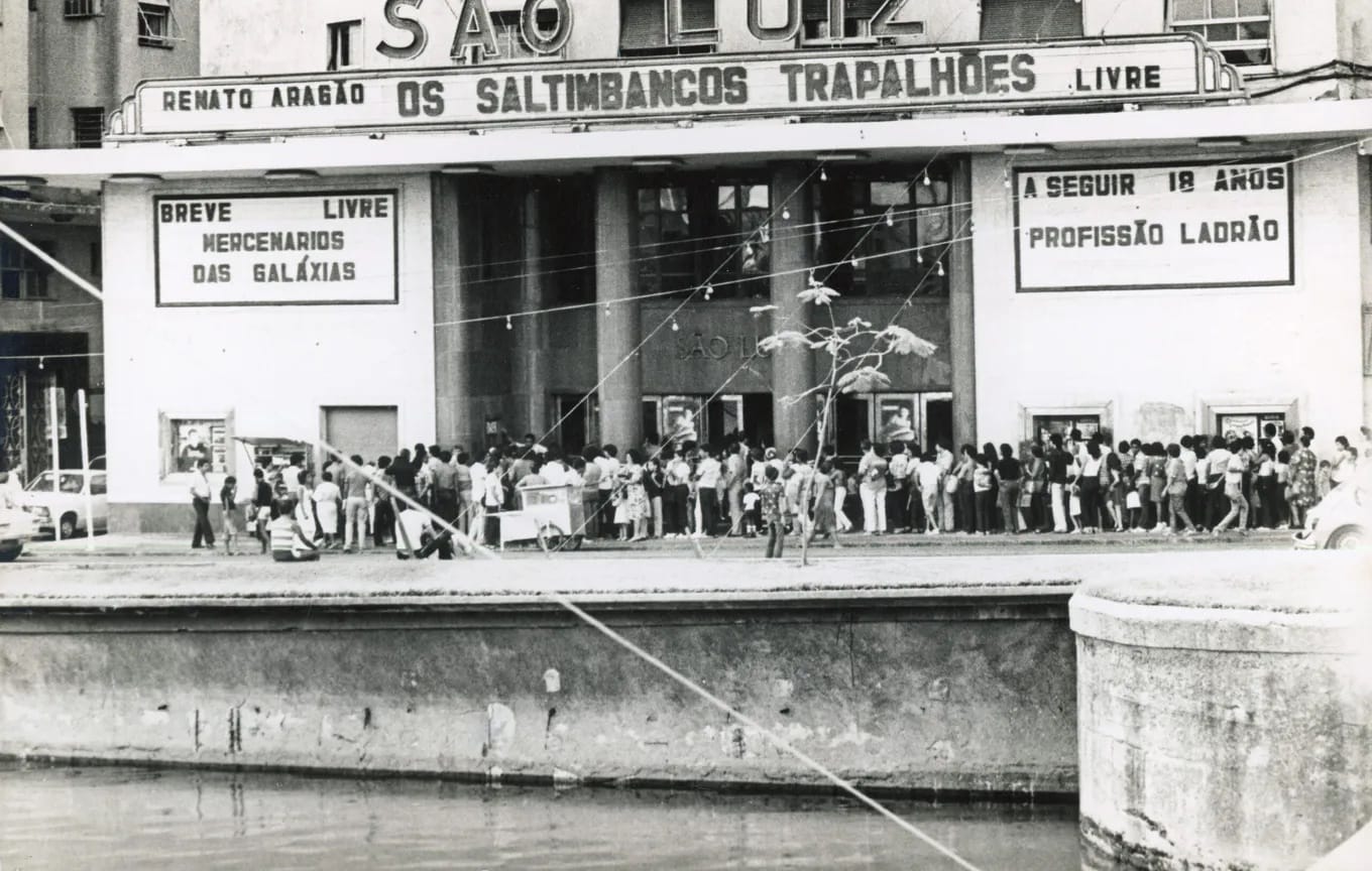 black and white photo of a crowd of people in front of a movie theater